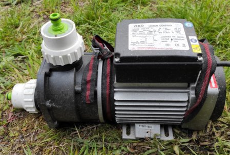 Elektrisk pump placerad på gräs för användning med LBC-tankar kopplat till stuprör.
