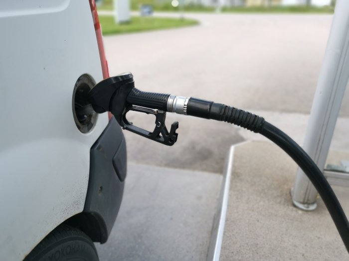 Bränslepump munstycke insatt i en bilens tanklock för påfyllning av bränsle.