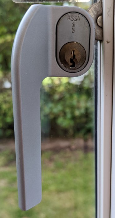 ASSA låscylinder i en dörr med fokus på nyckelhålet och låsmechanismen.