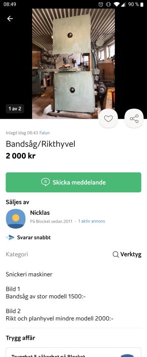 Grå målad bandsåg i en verkstad med andra snickerimaskiner i bakgrunden.