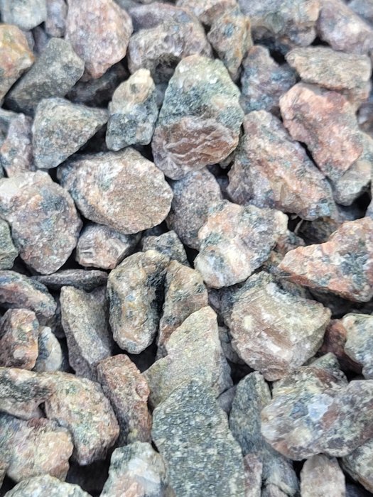 Närbild av en samling färgade krossade stenar för byggnation eller trädgårdsdekoration.