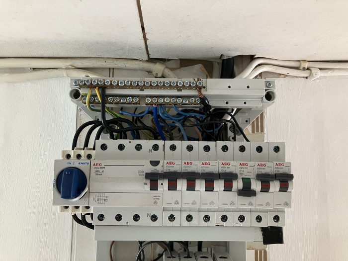 Elcentral med säkringar och ledningar, en del märkt med "X" och ovanlig färgkodning i bostad.