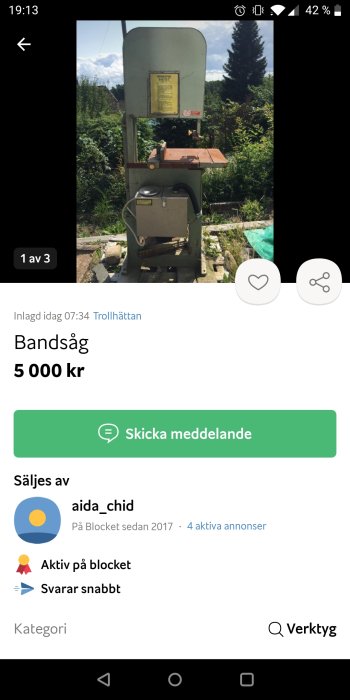 Bandsåg till salu placerad utomhus med grönska i bakgrunden.