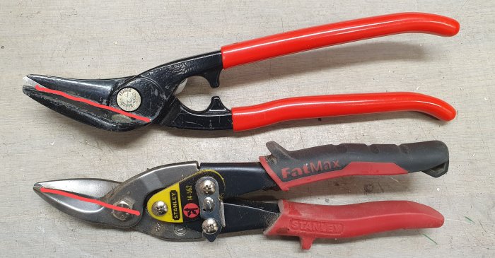 Två olika modeller av plåtsaxar med röda handtag, övre utan utväxling, nedre med utväxling och röda markeringar.