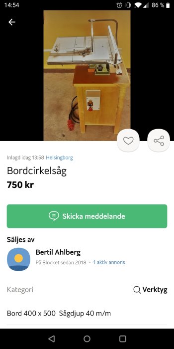 Bordcirkelsåg till salu, vit sågbord med sågblad och styrguide på trästativ, i en verkstad.