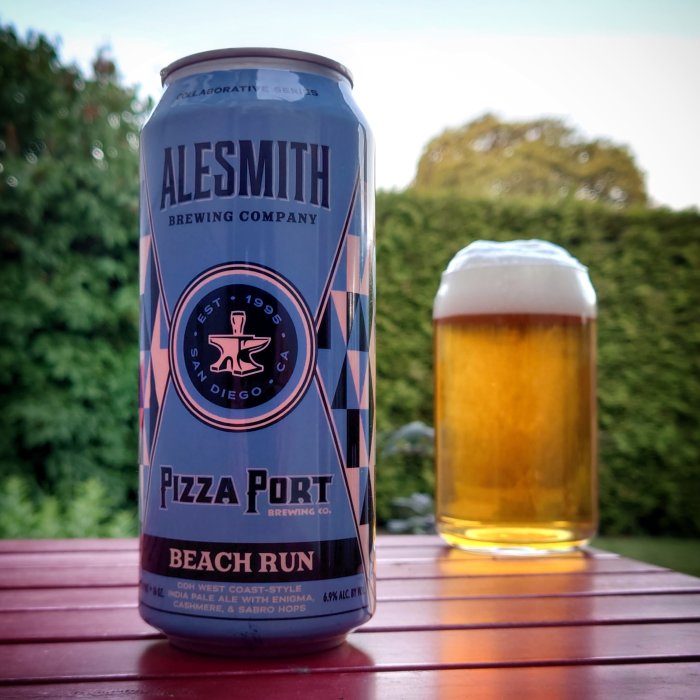 AleSmith bryggeriburk med logotyp och ett glas öl på ett träbord mot en grön bakgrund.