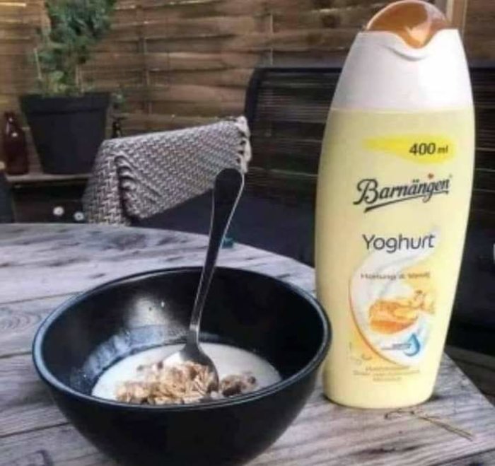 En skål med flingor och yoghurt med en sked i, bredvid en flaska Barnängen yoghurt.