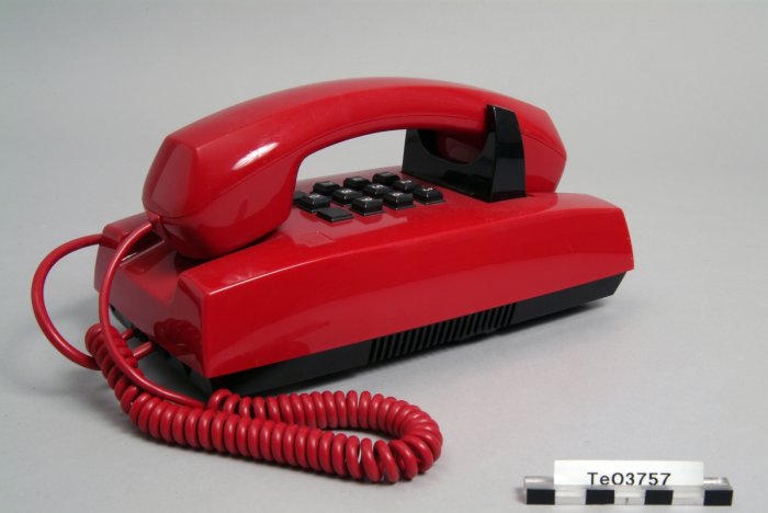 Röd vintage Diavox-telefon från 70-80-talet på grå bakgrund.