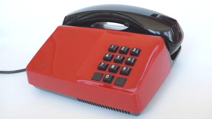 Röd Diavox-telefon från 70-80-talet med svart lur och knappsats.