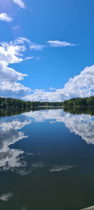 Spegling av molnig himmel i Magelungens lugna vatttenyta kl 14:15.