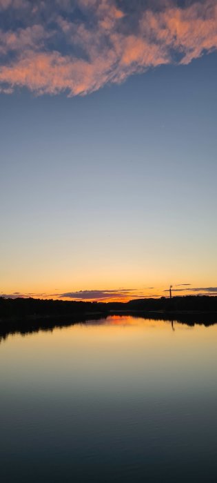 Solnedgång över Magelungen med spegelblankt vatten och färgsprakande himmel.