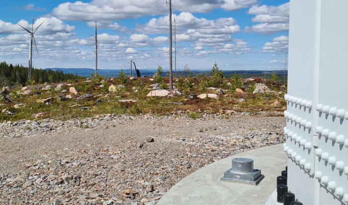 Vy från vindkraftspark i Mullbergs Vind, med vindkraftverk och besöksplatsens detaljer mot en bakgrund av Oviksfjällen.