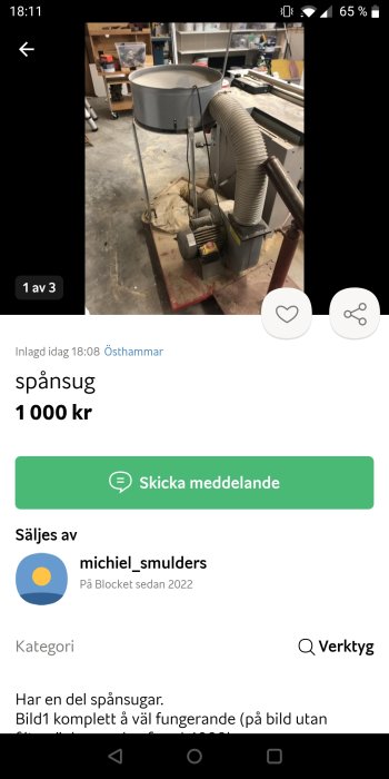 Spånsug i verkstad med tillbehör och slangar synlig på en belamrad arbetsyta.