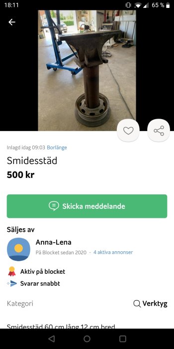 Begagnat smidesstäd på en brun metallpelare med en stålfälg som fot i ett garage.