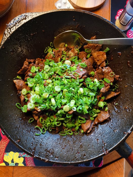 Stekpanna med yakiniku gjord på svensk lövbiff, toppad med skivad vårlök.