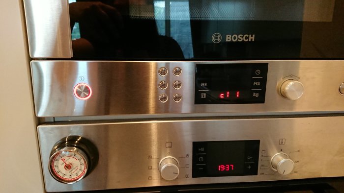 Bosch inbyggnadsmicro och ugn med aktiv on/off-knapp och konstig text på displayen.