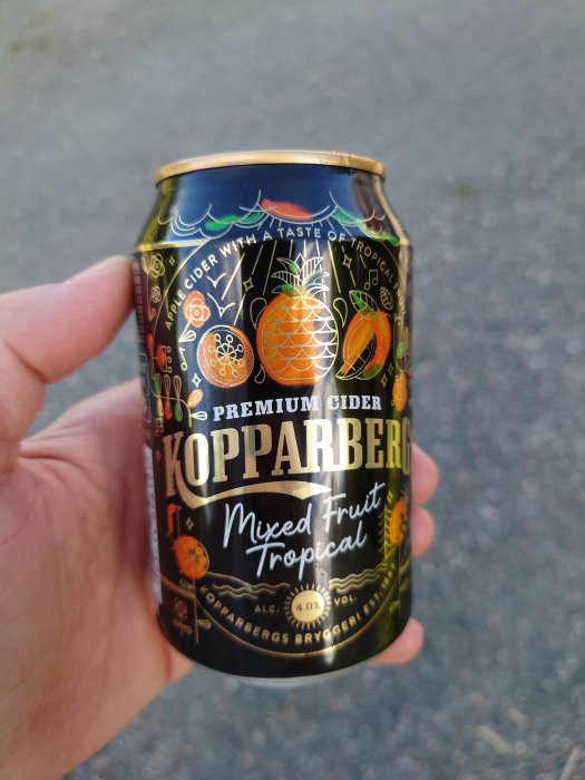 Hand håller en burk Kopparberg Premium Cider Mixed Fruit Tropical.