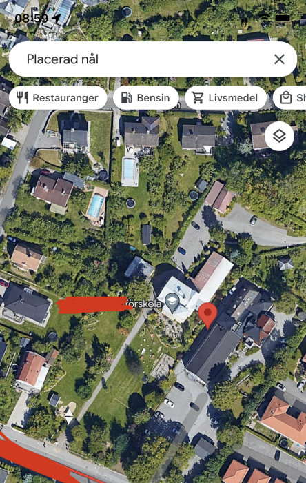 Flygbild över ett bostadsområde med en förskola och två grannhus med pooltak.