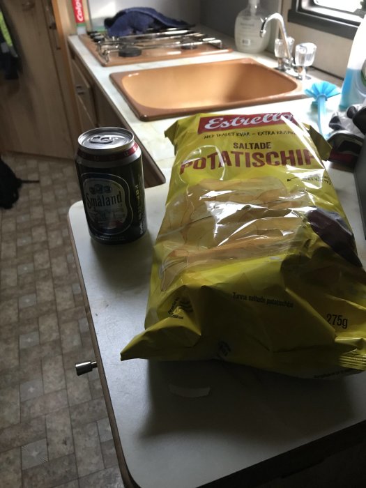 Bild på ett köksbord med en öppnad påse chips och en burk läsk, förberedelse för en paus.