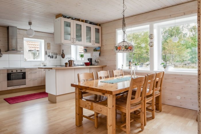 Kök med liggande vit hårdvaxoljad träpanel på väggarna och ljus inredning.