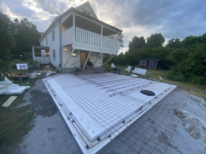 Förberedelse för betonggjutning av altan, armeringsnät på cellplastskivor framför hus.