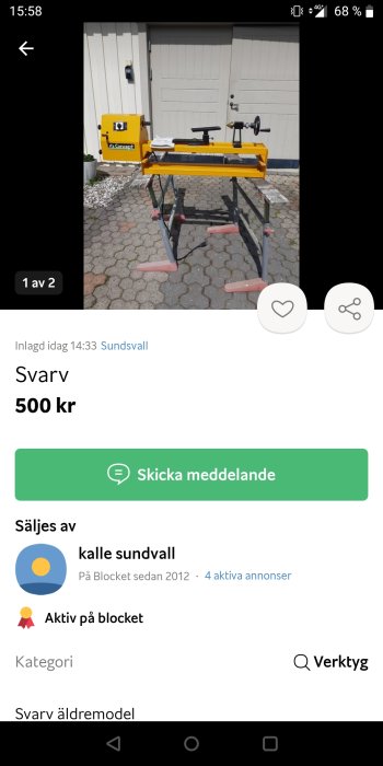 Gul och svart trä svarv maskin på ett stativ framför en vit garageport, till salu för 500 kr.