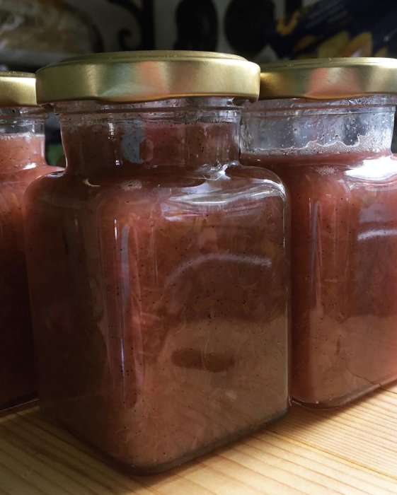 Burkar med hemgjord rabarbermarmelad på en köksbänk.