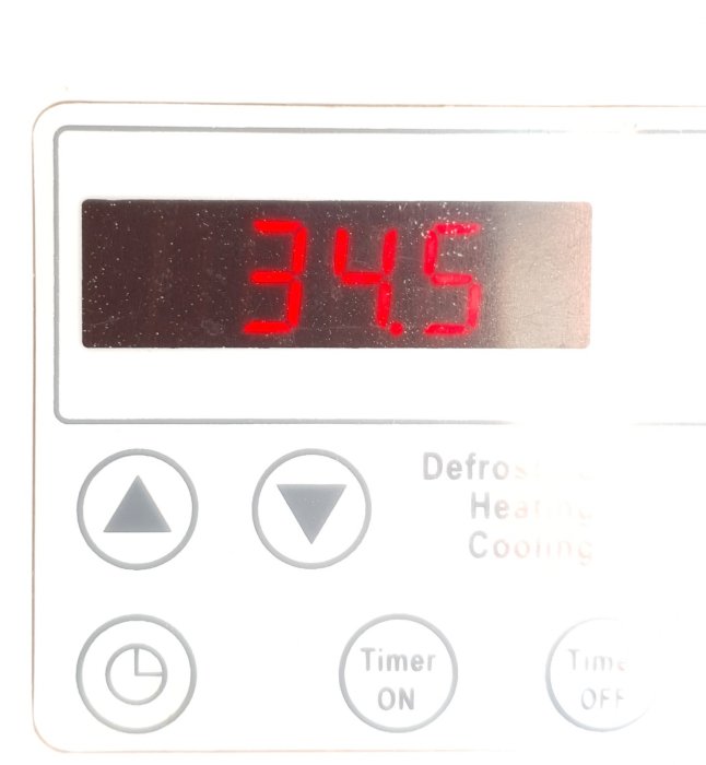 Digital termometer visar hög temperatur på 34,5 grader Celsius.