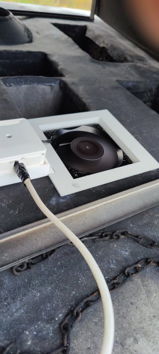 12V datorfläkt monterad i tak för ventilation med synlig kabelanslutning och öppen skorsten i bakgrunden.