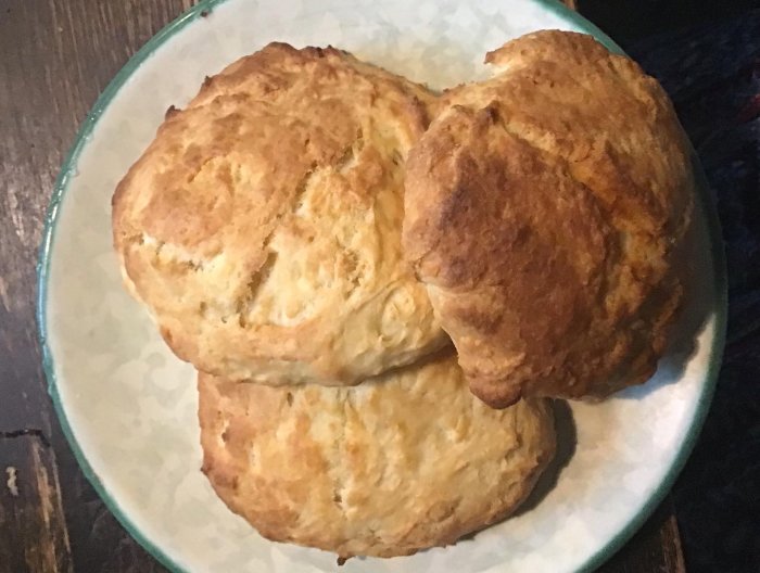 Nybakade scones på en tallrik, redo att ätas med hemgjord rabarbermarmelad.