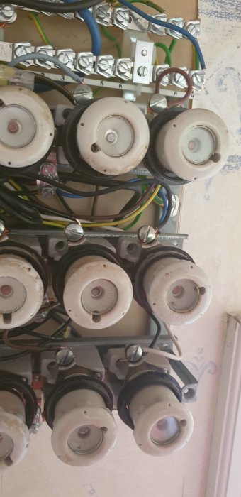 Nyinstallerat 3-fasuttag med sladdar inkopplade till el-central, jord och nollar anslutna, synliga säkringar.