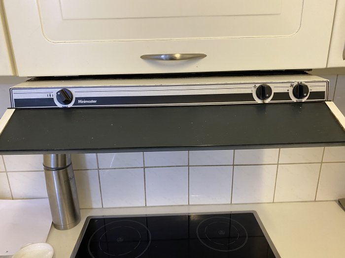 Gammal värmeåtervinningsenhet över spishäll med synlig rost och slitage.