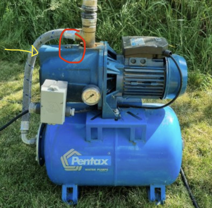 Vattenpump märkt "Pentax" med röd markering vid skruv och gul pil som visar inkommande slanganslutning.