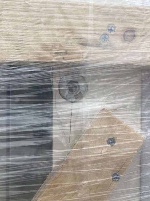 Närbild på en karmhylsa på ett fönster som orsakat en spricka i träet vid smygspåret.