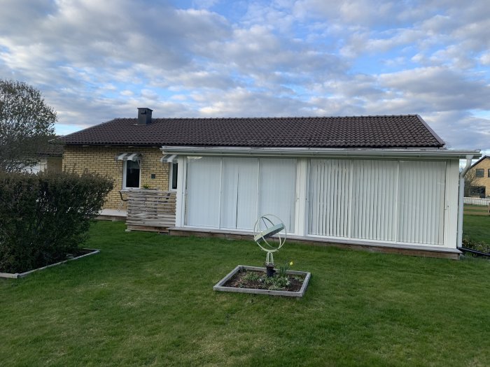 Ett enfamiljshus med solpaneler på taket och en låst elprisaffisch på väggen.