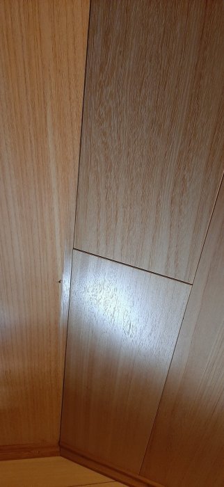 Ljust träinnertak i en vinkel på vinden med synliga skarvar och brädor.