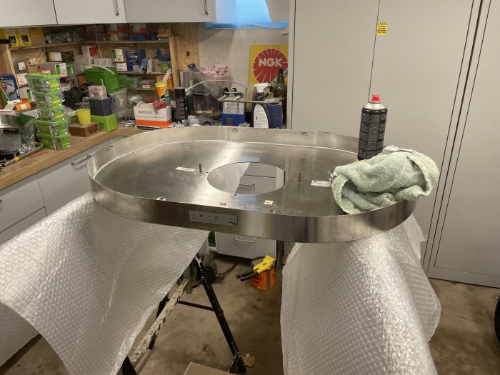 Rengjord och frihängande köksfläkt på 900mm (Thermex Ronda) som vilar på bubbelplast med en verkstad i bakgrunden.