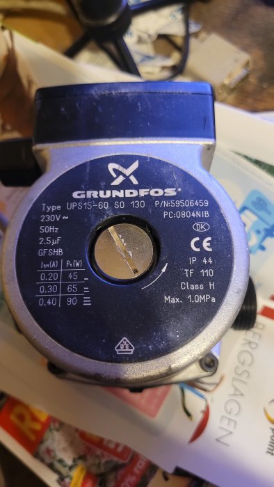 Grundfos cirkulationspump med tydliga specifikationsetiketter och justerbar flödesskruv.