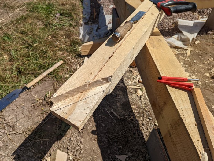 Snedsträva placerad på ramverk med utritade kaplinjer, tving och blyertspenna syns i arbetsmiljö.