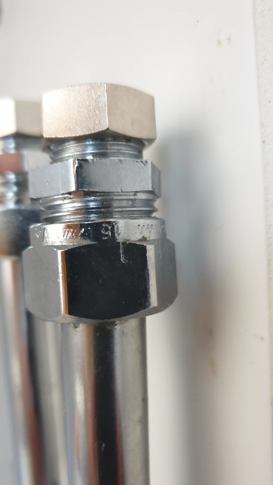 Närbild på anslutningen av en vattenledning med metallslangar och kopplingar
