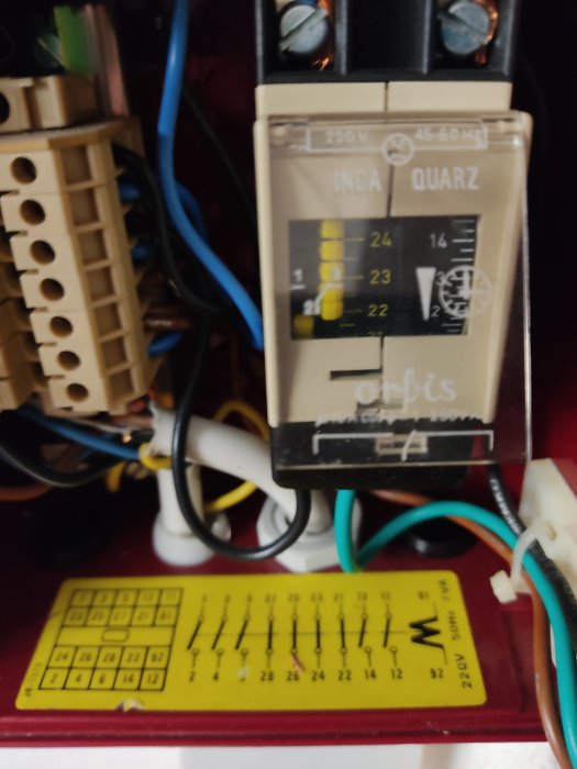Elektrisk timer för belysning med kablar och en installationsguide på en vägg.