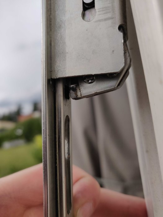 Närbild på en delvis ur funktion spanjolett på en altandörr som inte hakar i korrekt.