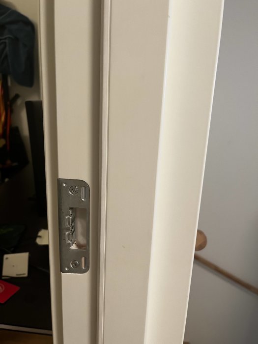 Vit dörrkarm med detaljerat foder och silverfärgat låshus.