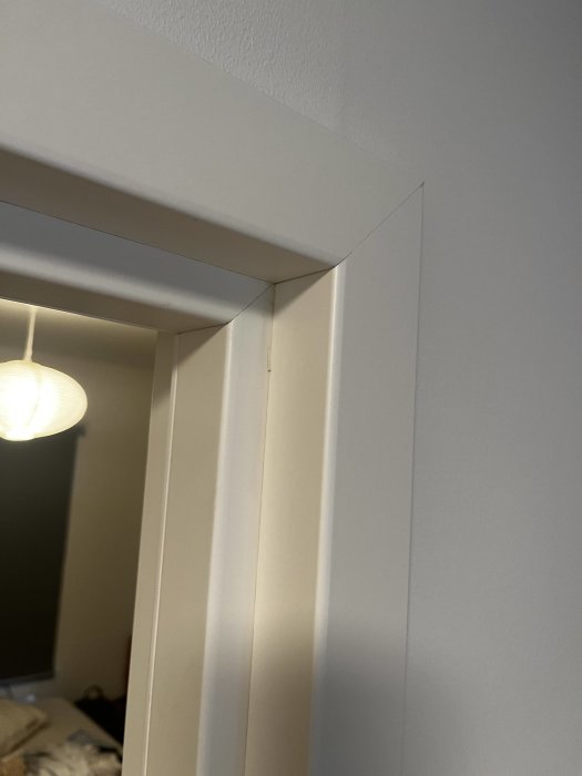 Vit dörrkarm med djup salning som liknar Swedoor Flex foder i en interiörmiljö.