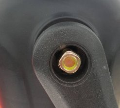 Fyrkantskruv med 1/4" fäste försänkt i ett smalt hål på en svart yta.