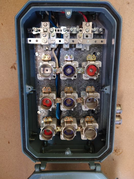 Öppen elektrisk central med olika kopplingar och passdelar i behov av justering och byten för säkerhet.