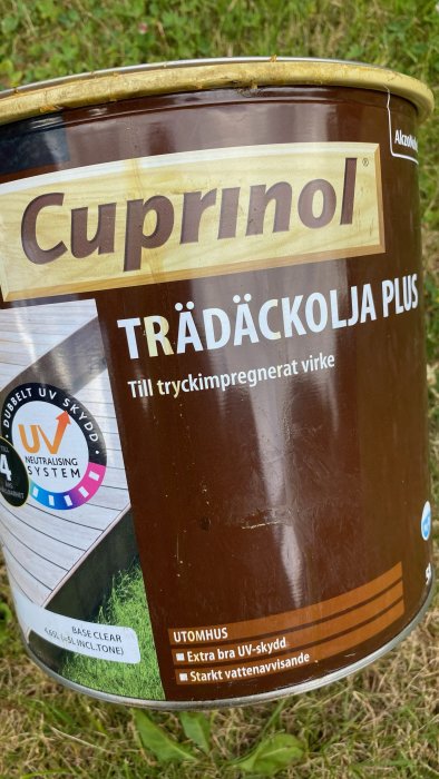 Burk av Cuprinol Trädäckolja Plus med etikett som anger UV-skydd och vattenavvisande för utomhusbruk.