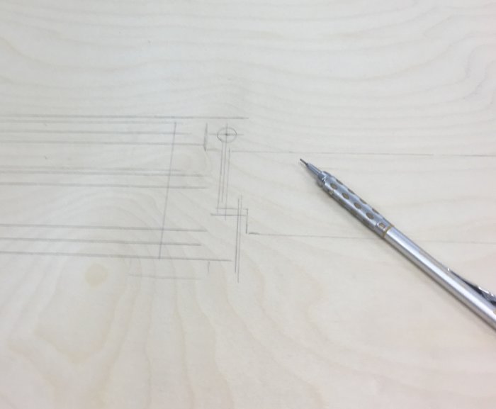 Ritning av dörrkarmens gångjärn och marginaler på träyta med en penna.