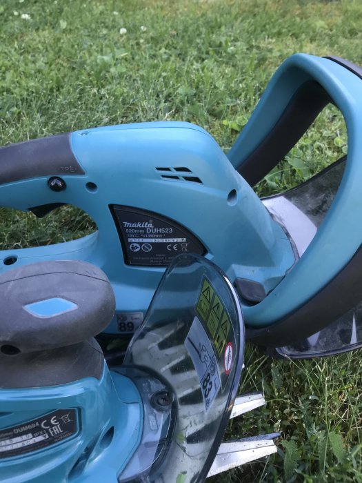 Makita DUR523 grästrimmer och DUM604 häcksax i gräset, använd för krypfuru-häck.