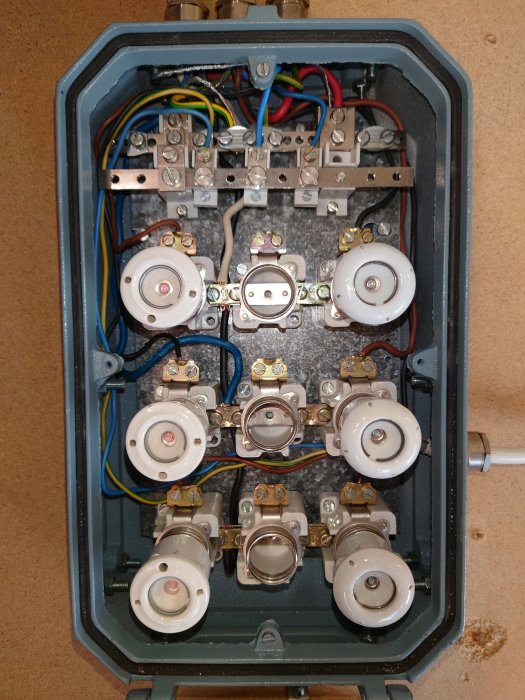 Elektrisk kopplingsdosa med slarvigt anslutna kablar och flera stickkontakter.